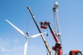 Construction of a wind power plant. Installers use a truck crane and aerial platform to raise the wind turbine rotor Royalty Free Stock Photo