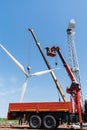 Construction of a wind power plant. Installers use a truck crane and aerial platform to raise the wind turbine rotor Royalty Free Stock Photo