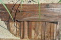 Construction wooden boards with old construction brown paint, green grass and sand after rain. Royalty Free Stock Photo