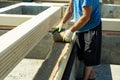 Construction of a wooden house made of profiled laminated veneer lumber. Laying insulation under the timber. Royalty Free Stock Photo