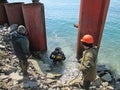 Russia, Nakhodka, Wrangel - 04.06.2016 Construction work of a coal berth, metal piles, lifting diver from depth