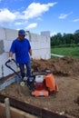 Construction work on the construction site, soil compaction with a vibrating plate, manual equipment Royalty Free Stock Photo