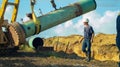 Construction work- the crane lifting the beam in the field and the workers looking at it Royalty Free Stock Photo