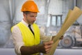 Construction work lifestyle portrait of young happy and attractive engineer or building contractor holding blueprints wearing Royalty Free Stock Photo