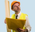 Construction work lifestyle portrait of young happy and attractive engineer or building contractor holding blueprints wearing Royalty Free Stock Photo