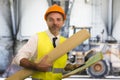 Construction work lifestyle portrait of young happy and attractive engineer or building contractor holding blueprints wearing Royalty Free Stock Photo