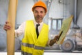 Construction work lifestyle portrait of young happy and attractive engineer or building contractor holding blueprints wearing Royalty Free Stock Photo