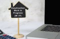 Construction Work in Progress text on wooden house model with on white table. Royalty Free Stock Photo