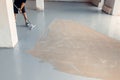 Worker apply grey epoxy resin in an industrial warehouse