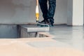 Worker apply grey epoxy resin in an industrial warehouse