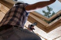 Construction Worker Applying Caulking to Sky Light