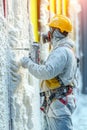 Construction Worker Applying Expanding Foam Insulation For Energy Efficiency In Building Wall Royalty Free Stock Photo