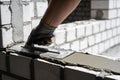 Construction worker applying mortar to white bricks with a trowel, building a wall Royalty Free Stock Photo