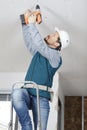 Construction worker assemble suspended ceiling with drywall Royalty Free Stock Photo