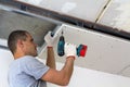 Construction worker assemble a suspended ceiling with drywall an