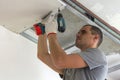 Construction worker assemble a suspended ceiling with drywall an