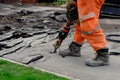 Construction worker breaking road gully using hydraulic breacker during road works on new housing development construction site Royalty Free Stock Photo