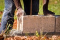 Construction worker/bricklayer/mason laying concrete block on wet cement