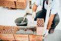 Industrial worker, bricklayer and mason working with bricks and building house