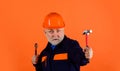 Construction worker or builder in safety hard hat with adjustable wrench and hammer. Bearded man in uniform with Royalty Free Stock Photo