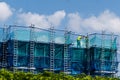Construction Worker on Building Scaffold with Safety Netting, building development, industrial safety, labor, and the housing Royalty Free Stock Photo
