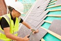 Construction Worker On Building Site Laying Slate Tiles