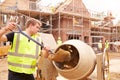 Construction Worker On Building Site Mixing Cement