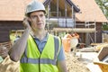 Construction Worker On Building Site Using Mobile Phone Royalty Free Stock Photo