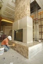 Construction worker building stone fireplace