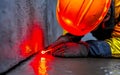 A construction worker carefully inspects a concrete wall using a red light, ensuring structural integrity Royalty Free Stock Photo