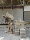 Construction worker carrying concrete block