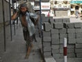 Construction worker carrying concrete block
