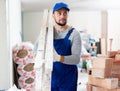 Construction worker carrying ladder at renovating object Royalty Free Stock Photo