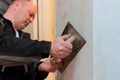 Construction worker checks the evenness the wall with a using