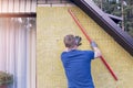 Construction worker checks the level of insulated house wall