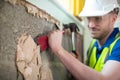 Construction Worker With Chisel Removing Plaster From Wall In Renovated House