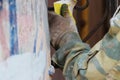 The construction worker is cleaning the rusty old grate at the arch of the old house in St. Petersburg with sandpaper