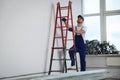 Construction worker climbing up stepladder in room prepared for renovation Royalty Free Stock Photo