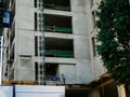 Construction worker at concrete building high ceiling high-rise apartment condo tower skyscraper with crane, scaffolding, safety Royalty Free Stock Photo