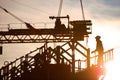 Construction worker, crane and building at sunset Royalty Free Stock Photo