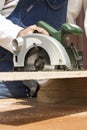 The carpenter cuts the board with a manual electric saw. Royalty Free Stock Photo