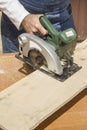 The carpenter cuts the board with a manual electric saw. Royalty Free Stock Photo