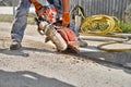 Construction worker cutting concrete foundation using a cut-off saw. Profile on the blade of an asphalt or concrete Royalty Free Stock Photo
