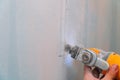 Construction worker cutting gypsum plasterboard by using electric cutter angle grinder