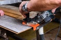 Construction worker cutting laminate using angle grinder with stand for 45 degree. Royalty Free Stock Photo