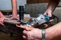 Construction worker cutting laminate using angle grinder with stand for 45 degree. Royalty Free Stock Photo