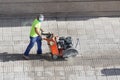 Construction worker cutting paving stone floor