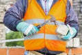 Construction worker divides brick with hammer