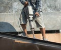 The construction worker is drilling the floor. Construction technicians use electric hammer chisels to destroy the floor Royalty Free Stock Photo