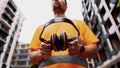 Construction worker with ear muff working at construction site. Worker puts on ear defenders to protect against sound. Taking care Royalty Free Stock Photo